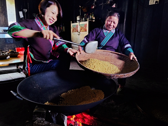 图2：侗寨妇女正在炒制糯谷.jpg