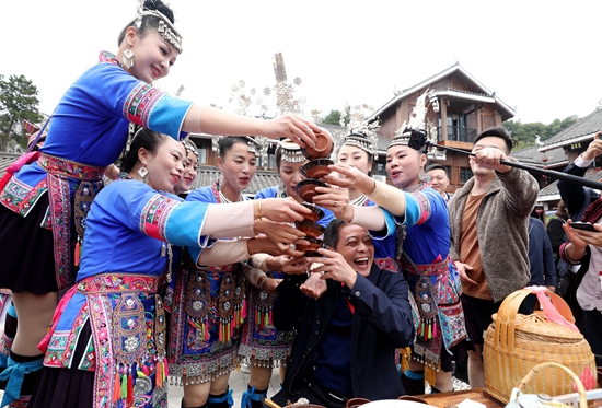 2022年10月28日，在2022年第四届广西稻渔丰收节活动现场，游客在体验侗族敬酒。_看图王.jpg